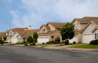 A suburban neighborhood with houses featuring similar architectural styles and landscaped yards.